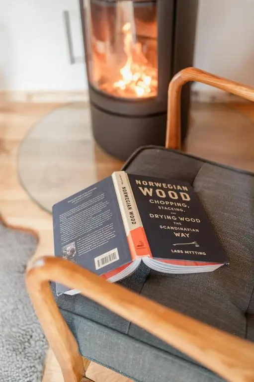 a book sitting on a chair in front of a fireplace at Osprey Lodge in Aviemore