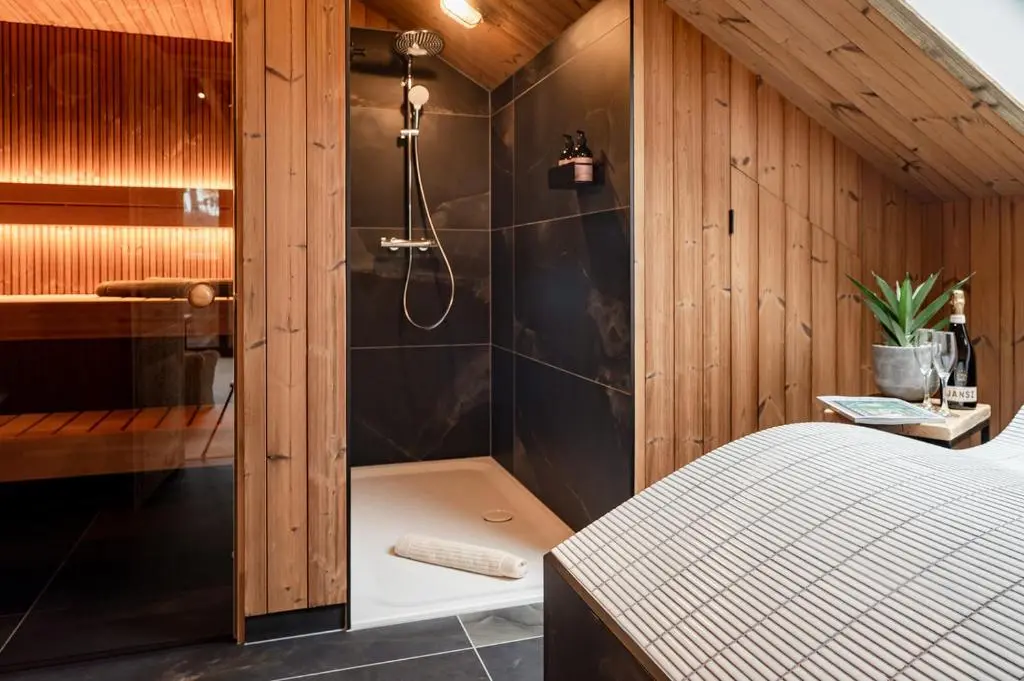a bathroom with a shower and a bed in a room at Osprey Lodge in Aviemore
