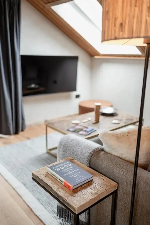 a living room with a couch and a table with a book at Osprey Lodge in Aviemore