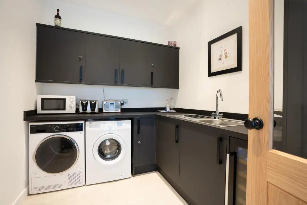 a laundry room with a washer and dryer and a sink at Pityoulish Steading - Seasgair Lodges in Aviemore