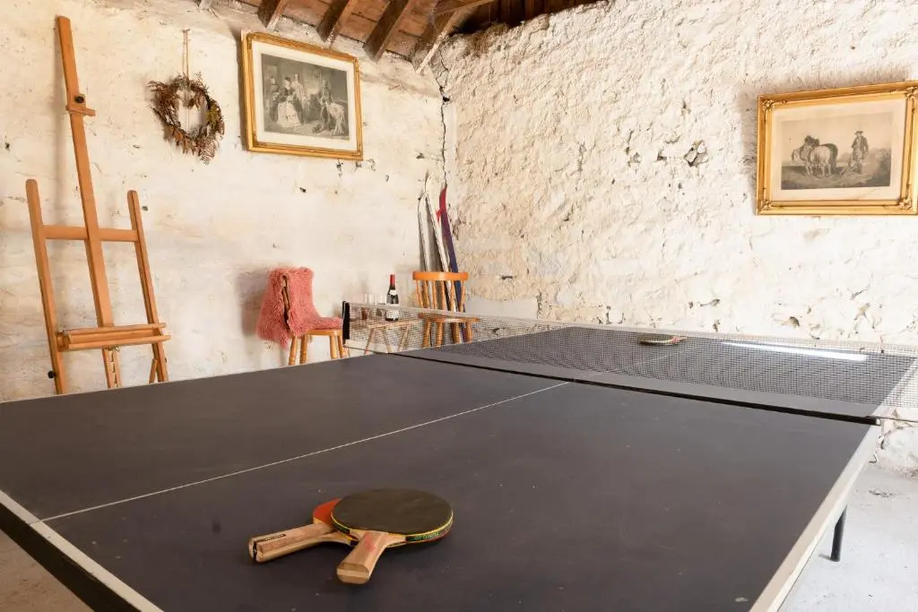 a ping pong table with a ping pong racket on it at Pityoulish Steading - Seasgair Lodges in Aviemore