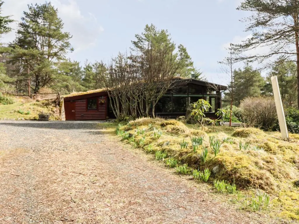 a barn with a dirt road in front of it at Rocksite in Blairgowrie