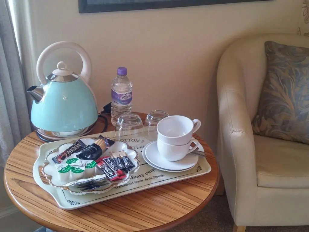 a table with a teapot and a plate of food at Heathcote B&B in Inverness