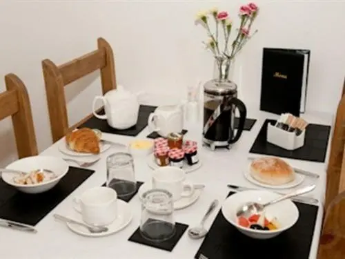a table with plates and bowls of food on it at Heathcote B&B in Inverness