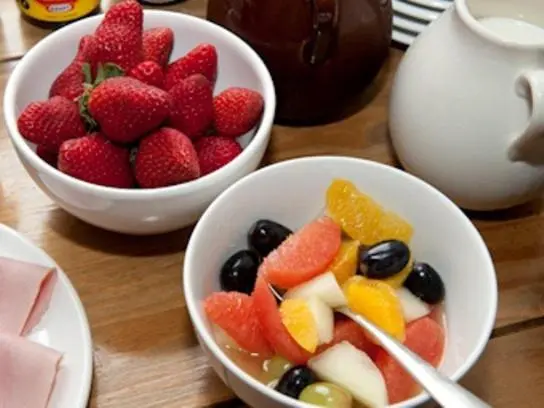 two bowls of fruit on a wooden table at Heathcote B&B in Inverness