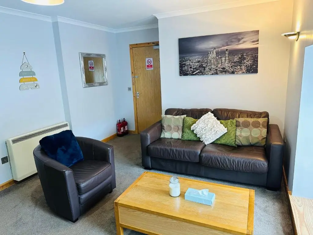 a living room with a couch and a chair at The Old Salt House, Flat1 in Wick