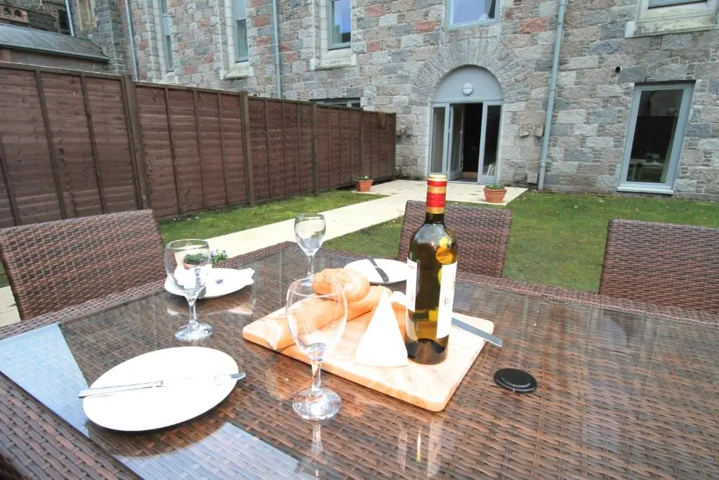 a bottle of wine sitting on a table with wine glasses at Abbey Garden at the Highland Club in Fort Augustus