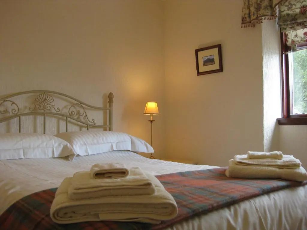 a bedroom with a bed with towels on it at Ardmuir in Turriff