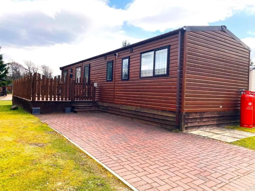 a tiny house is sitting on a brick driveway at Cabin 38 in Aviemore