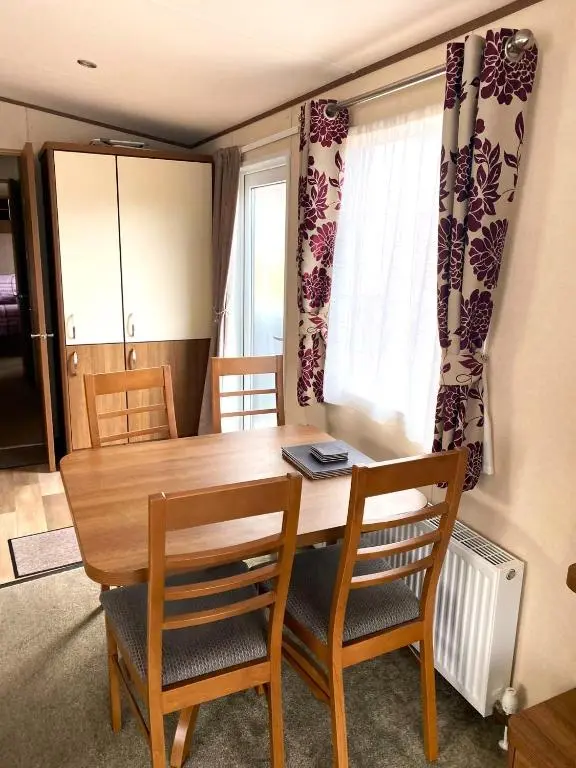 a dining room table with two chairs and a table at Cabin 38 in Aviemore