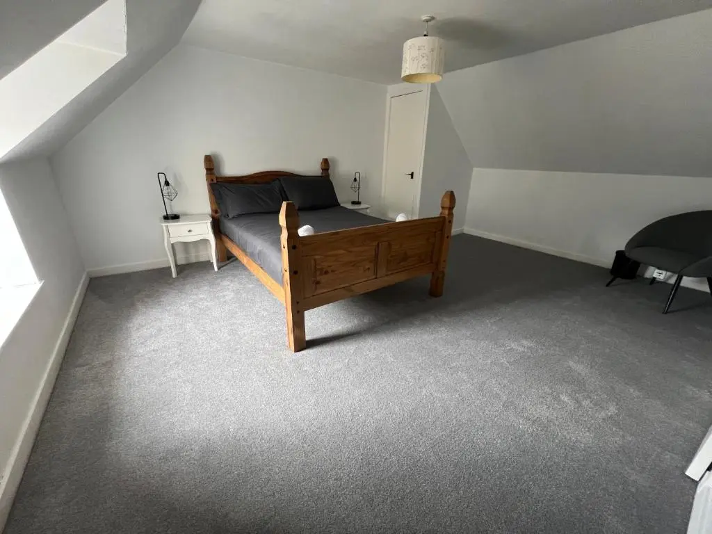 a bedroom with a wooden bed in a attic at MaCaMor in Helmsdale