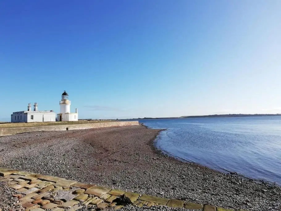 a lighthouse on the shore of a beach at Applegrove, perfect 2 bed bungalow, Fortrose in Fortrose