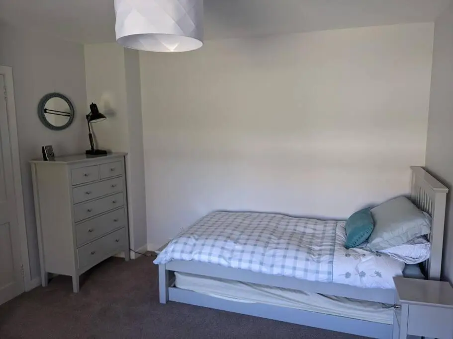 a bedroom with a bed and a dresser and a mirror at Applegrove, perfect 2 bed bungalow, Fortrose in Fortrose