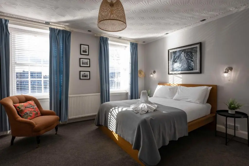 a hotel room with a bed and a chair at River View City Centre- Free Parking in Inverness