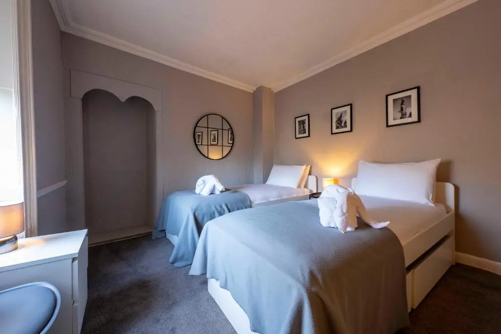 a hotel room with two beds and a mirror at River View City Centre- Free Parking in Inverness