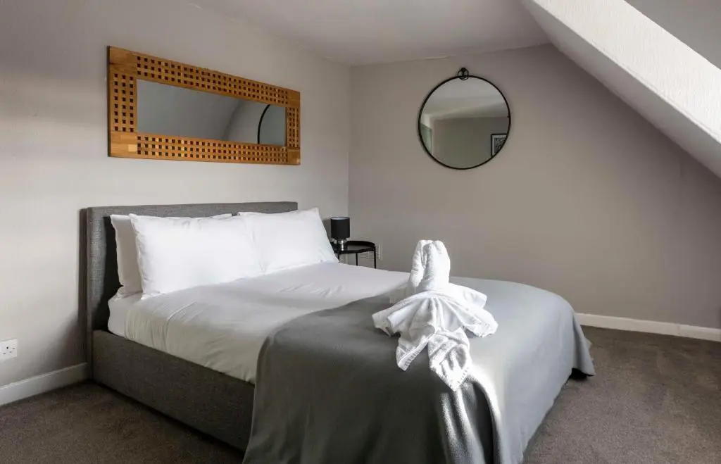 a bedroom with a bed and a mirror on the wall at River View City Centre- Free Parking in Inverness