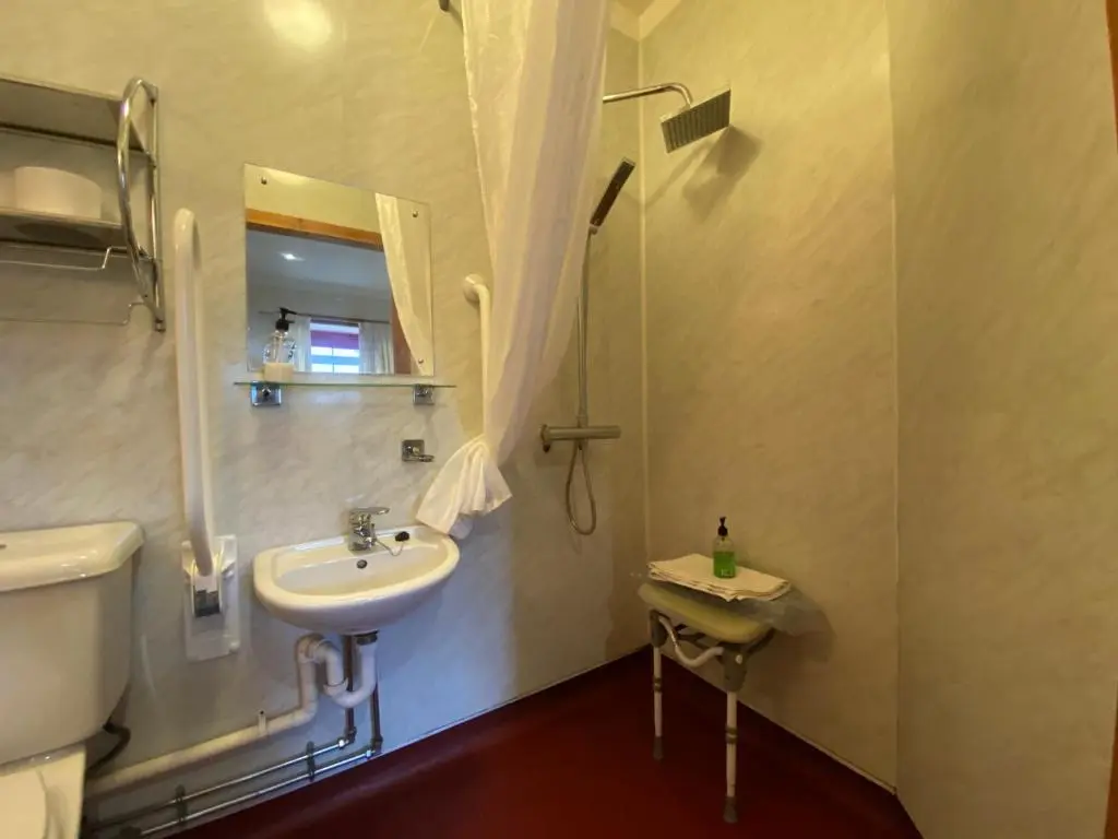 a bathroom with a sink and a toilet and a mirror at Columba House in Kingussie