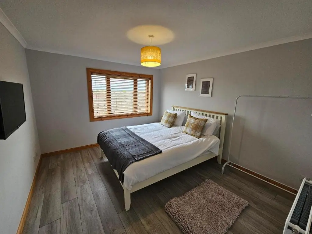 a bedroom with a large bed with a window and a window at NO 40 - 3 bed all with smart tv FULLY FITTED KITCHEN, Spacious living accommodation, FREE PARKING - ideal for TRADES, reduction for LONG STAYS part of Langley Cottages and Apartments in Wick