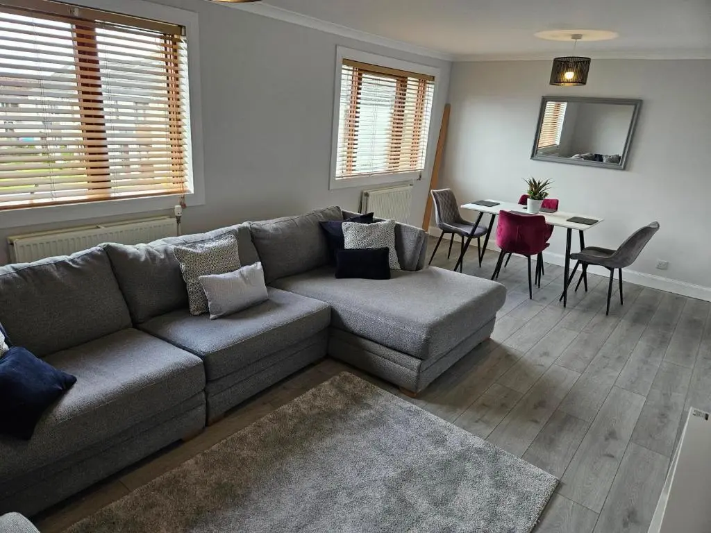 a living room with a couch and a table at NO 40 - 3 bed all with smart tv FULLY FITTED KITCHEN, Spacious living accommodation, FREE PARKING - ideal for TRADES, reduction for LONG STAYS part of Langley Cottages and Apartments in Wick