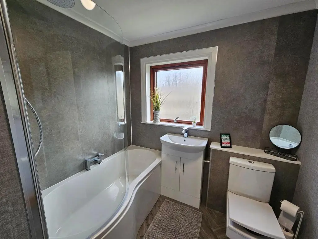 a bathroom with a tub and a toilet and a sink at NO 40 - 3 bed all with smart tv FULLY FITTED KITCHEN, Spacious living accommodation, FREE PARKING - ideal for TRADES, reduction for LONG STAYS part of Langley Cottages and Apartments in Wick