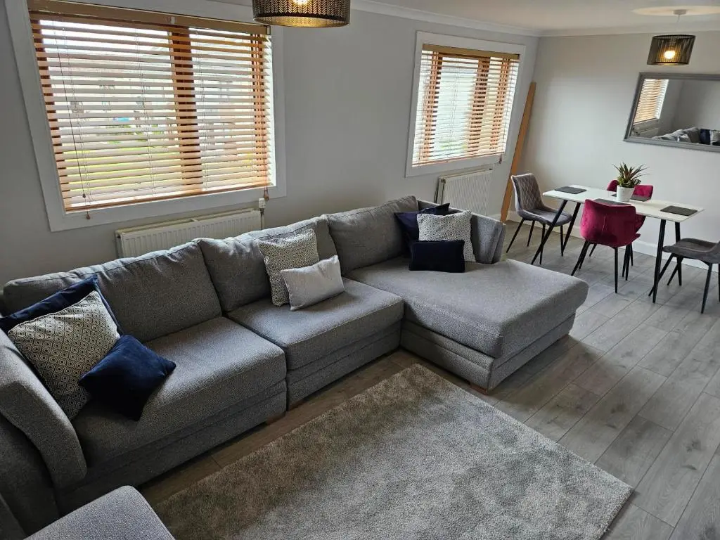 a living room with a couch and a table at NO 40 - 3 bed all with smart tv FULLY FITTED KITCHEN, Spacious living accommodation, FREE PARKING - ideal for TRADES, reduction for LONG STAYS part of Langley Cottages and Apartments in Wick