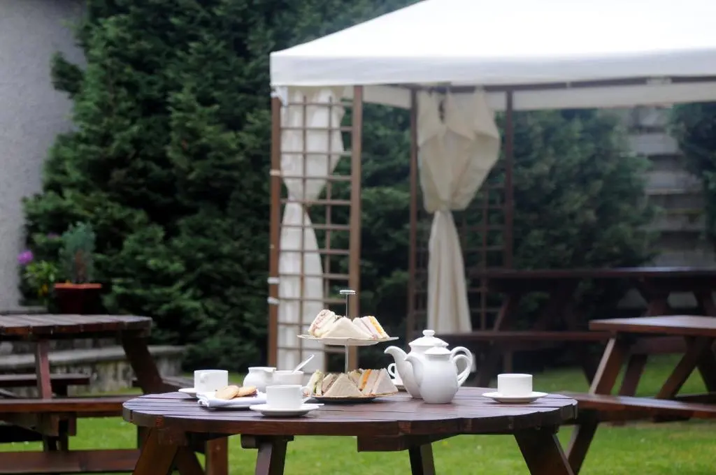 a picnic table with a tea set on top of it at Highlander Hotel \u2018A Bespoke Hotel\u2019 in Newtonmore