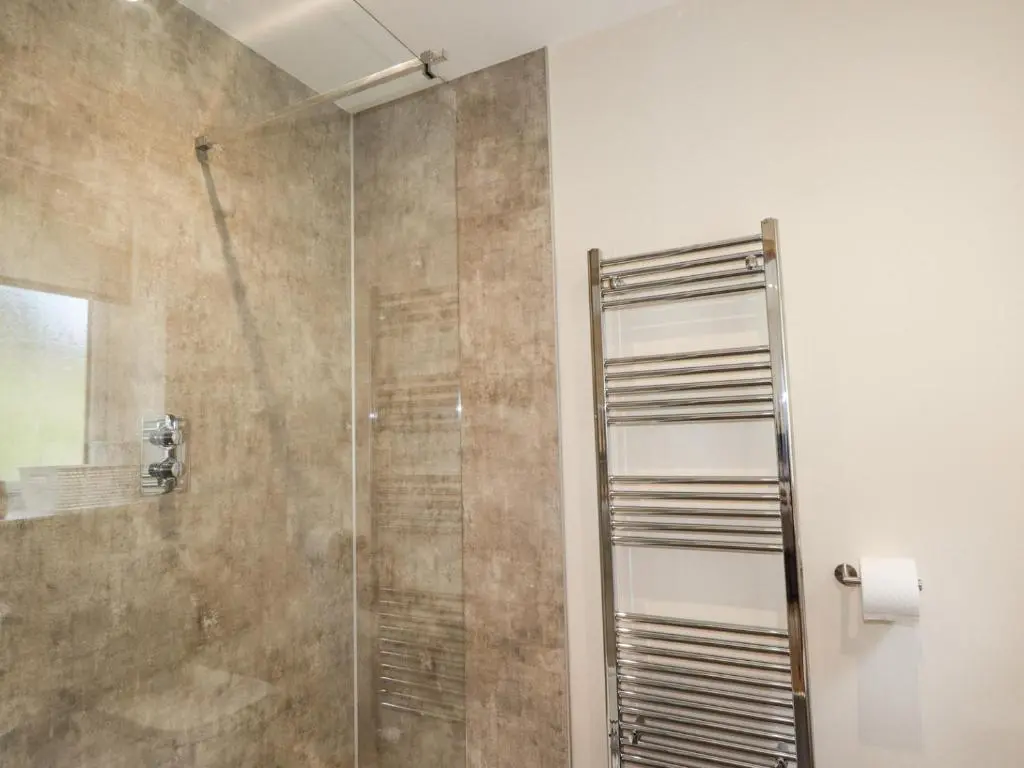 a shower with a glass door in a bathroom at Crask Bungalow in Beauly