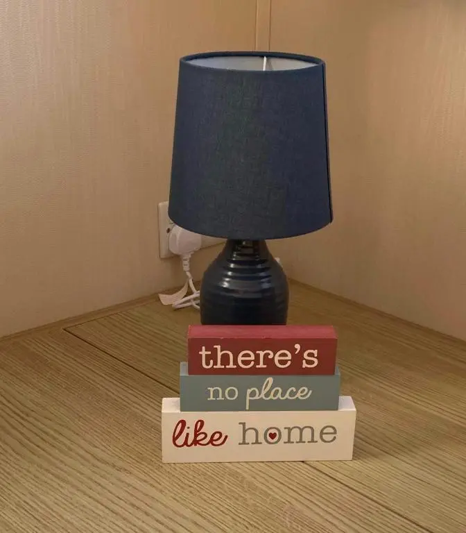 a lamp sitting on a table with a stack of books at Highway in Lossiemouth