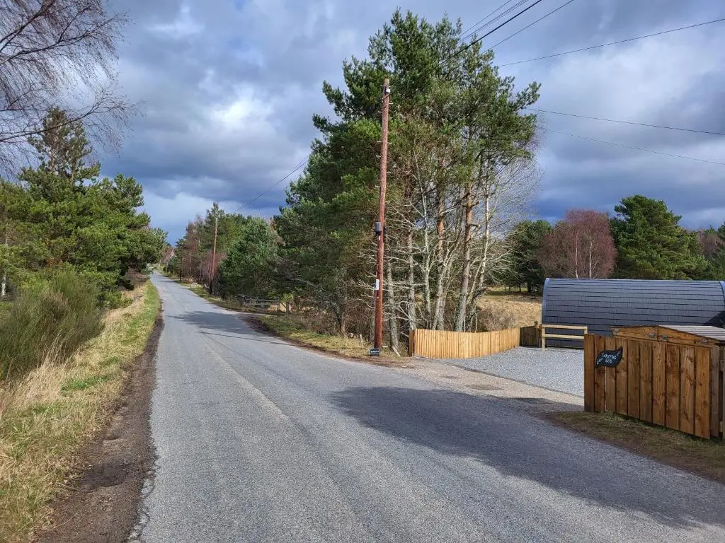 an empty road with a fence on the side at Tanleys - Skye Pod in Grantown on Spey