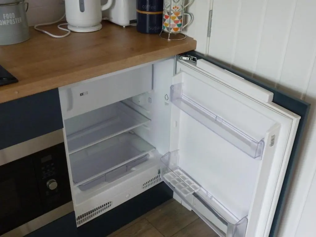an empty refrigerator with its door open in a kitchen at Tanleys - Skye Pod in Grantown on Spey