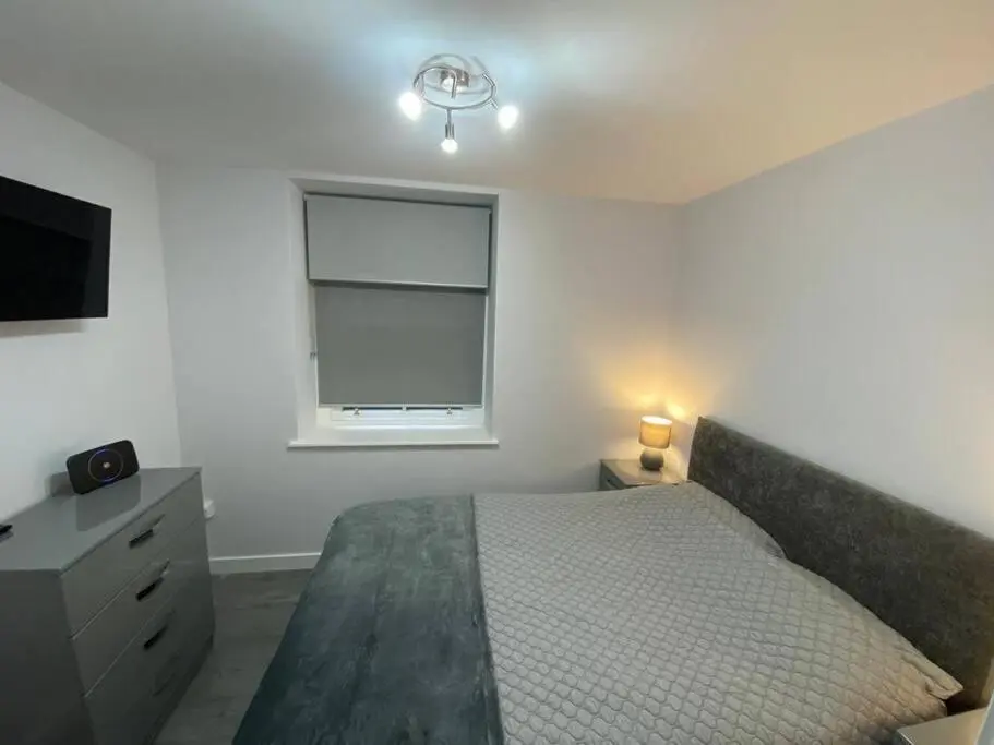 a bedroom with a bed and a window and a television at Modern Apartment - Wick Harbour in Wick
