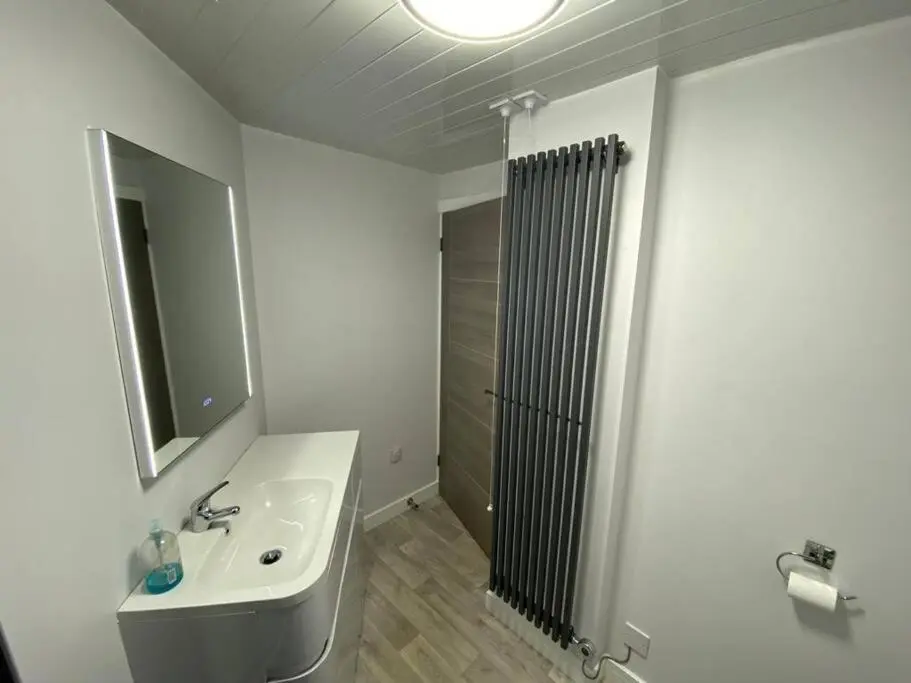 a bathroom with a sink and a mirror and a shower at Modern Apartment - Wick Harbour in Wick