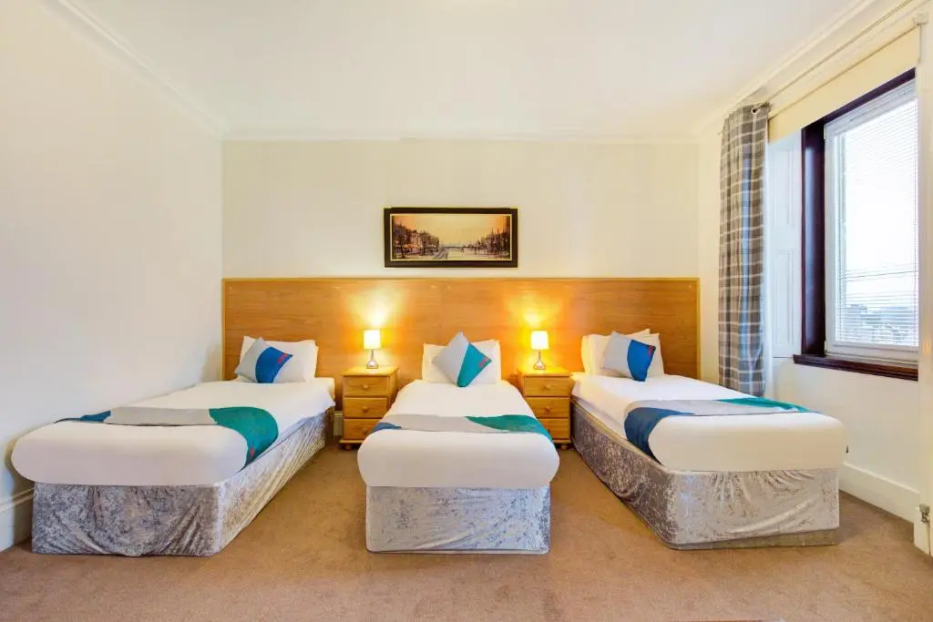 a hotel room with two beds and a window at OYO Eastbank Hotel, Speyside Scotland in Rothes