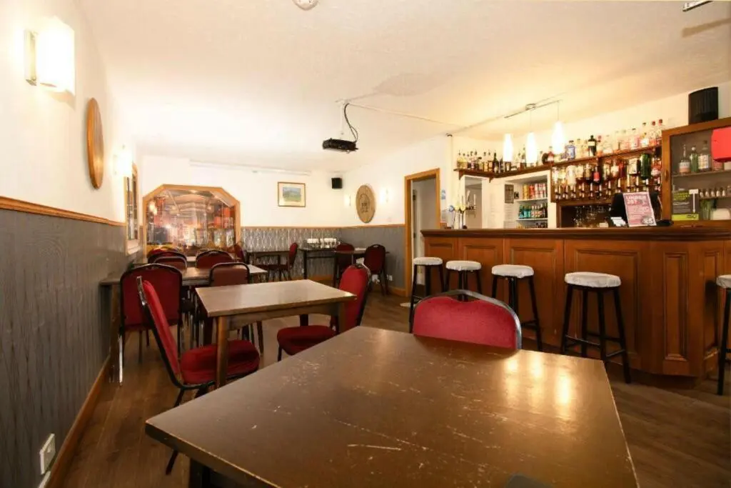 a restaurant with tables and chairs and a bar at OYO Eastbank Hotel, Speyside Scotland in Rothes