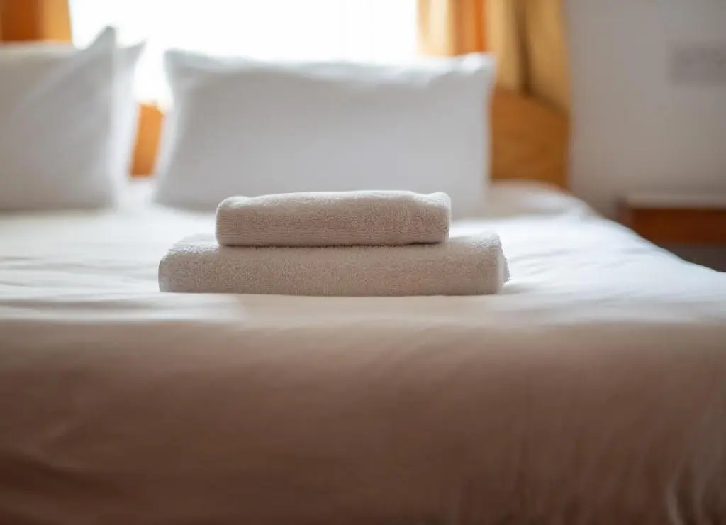 two towels sitting on top of a bed at Insh Hall Rooms at Loch Insh in Kincraig