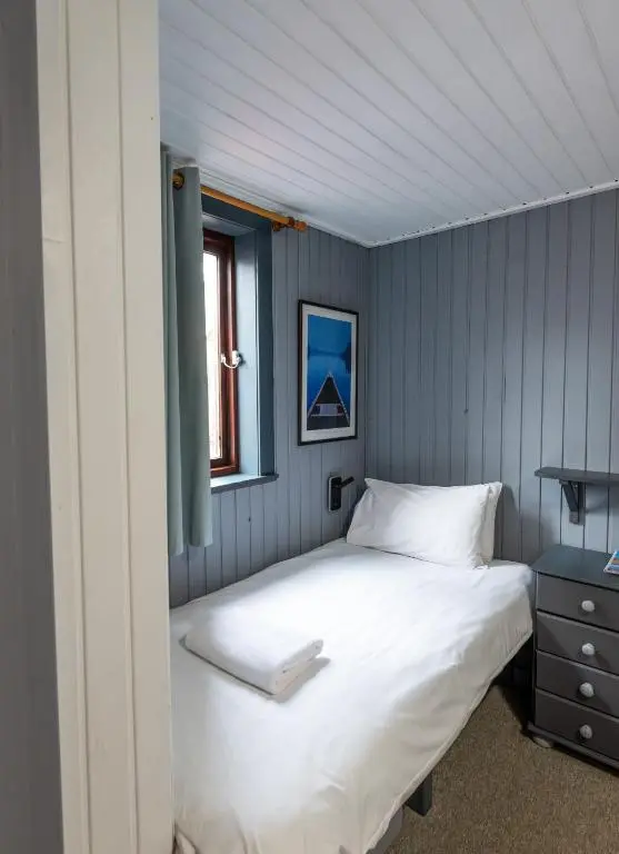 a bedroom with a white bed and a window at Insh Hall Rooms at Loch Insh in Kincraig