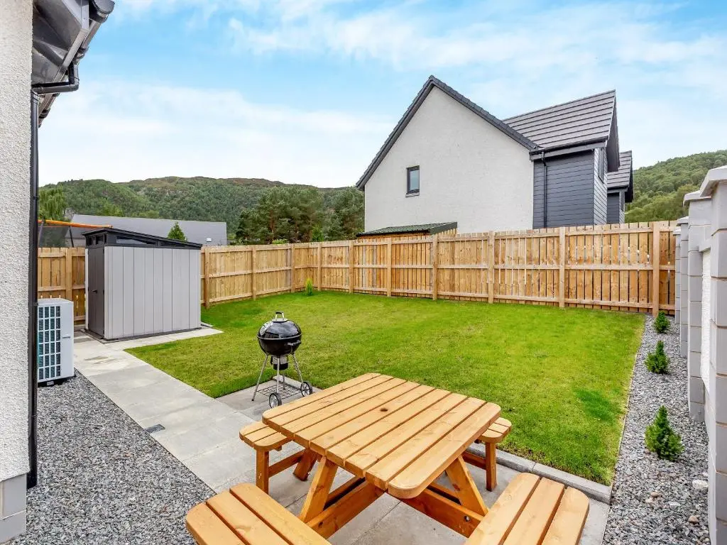 a backyard with a picnic table and a grill at The Beech House in Aviemore