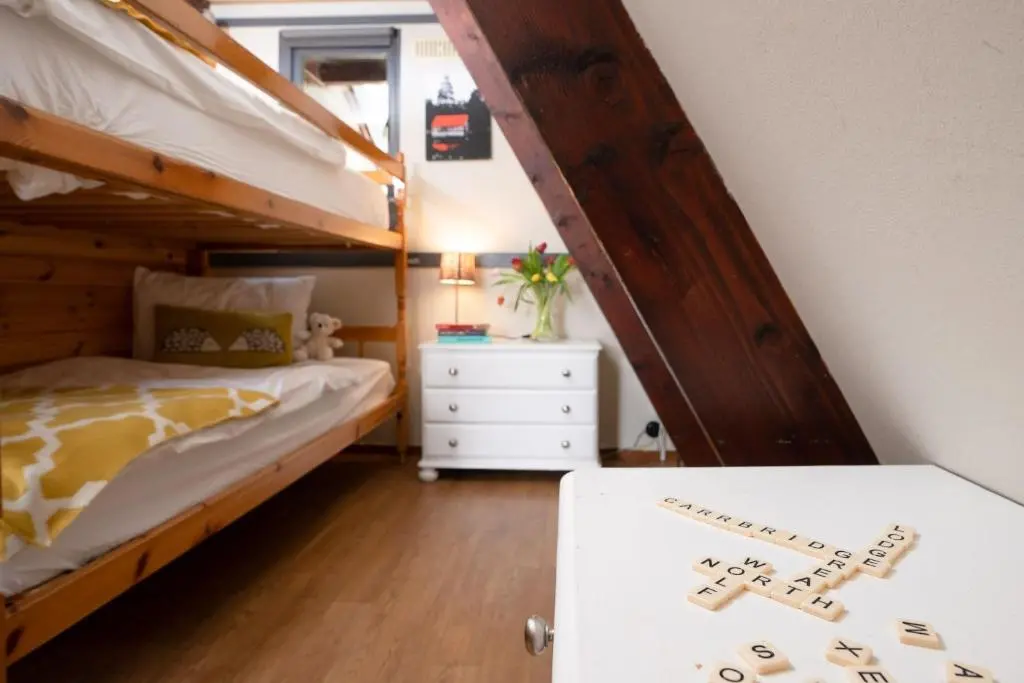 a bedroom with a bunk bed and a white dresser at Wolf Lodge in Carrbridge