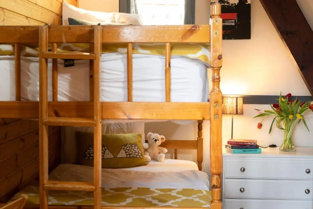 a bunk bed with a teddy bear in a bedroom at Wolf Lodge in Carrbridge