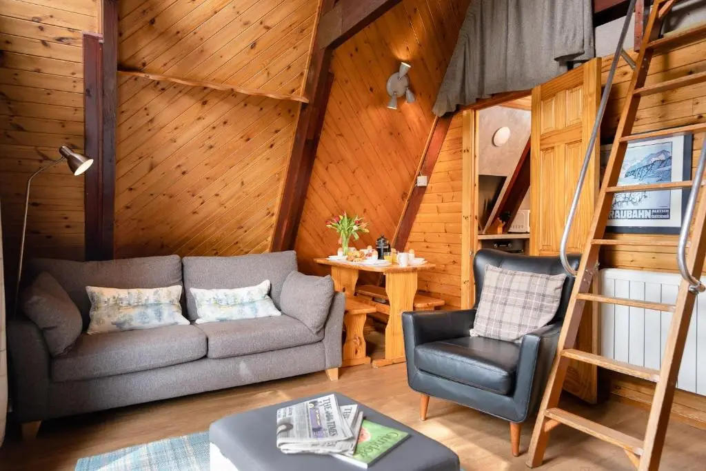 a living room with a couch and a chair at Wolf Lodge in Carrbridge