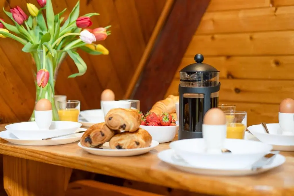 a table with eggs and bread and a coffee maker at Wolf Lodge in Carrbridge