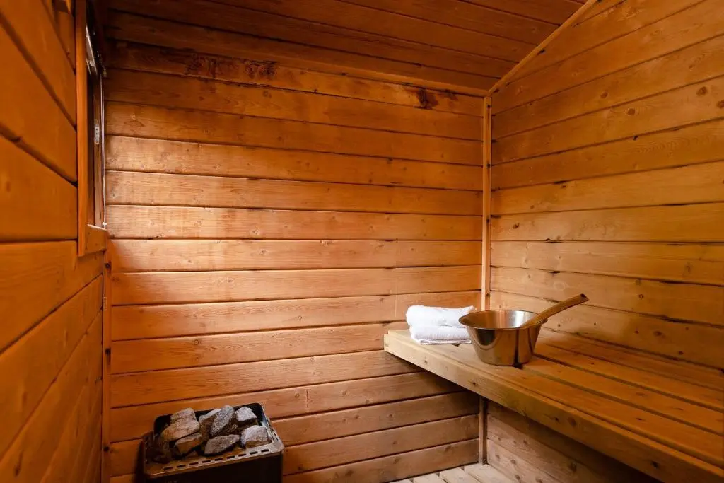 a wooden sauna with a bucket on a shelf at Wolf Lodge in Carrbridge