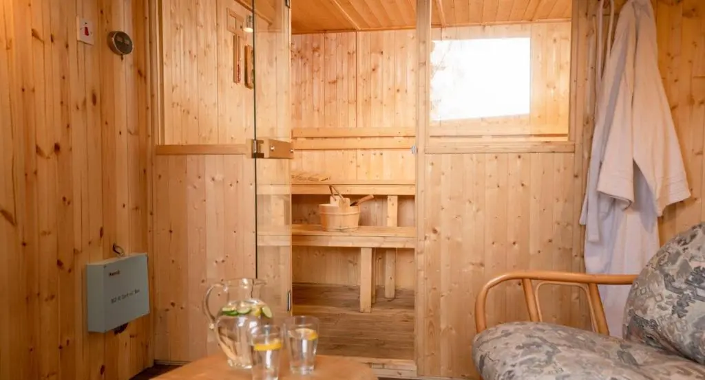 a wooden room with a table and a window at Salmon Run Lodge in Carrbridge