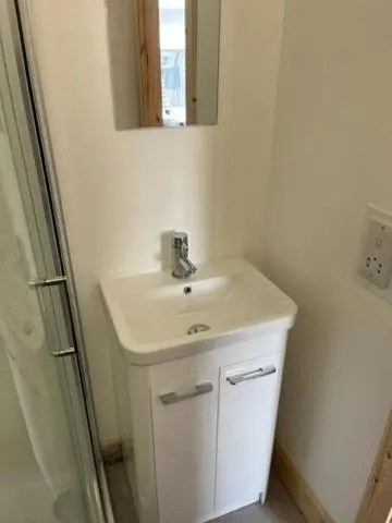 a bathroom with a white sink and a mirror at Duchally House in Nairn