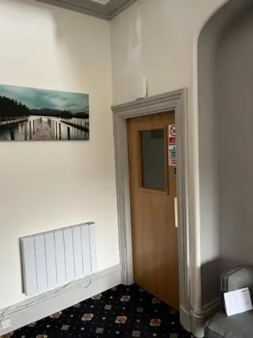 a hallway with a door and a picture on the wall at Duchally House in Nairn