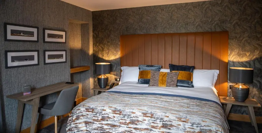 a bedroom with a large bed with a wooden headboard at Heathmount Hotel in Inverness