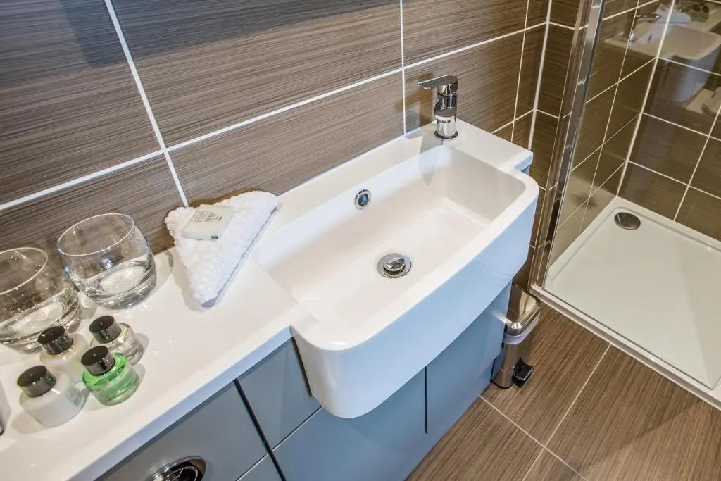 a bathroom with a white sink and a shower at Heathmount Hotel in Inverness