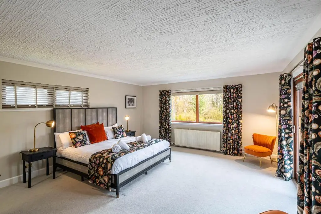 a bedroom with a bed and a window at Corrie House with Hot Tub in Belladrum