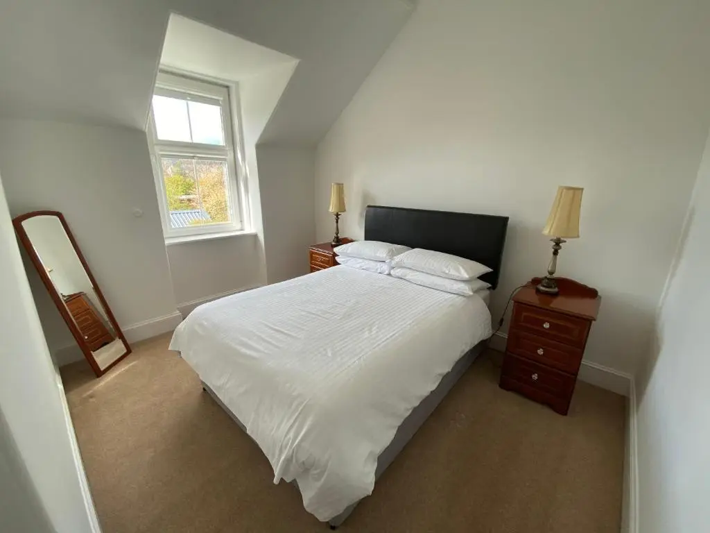 a bedroom with a white bed and a window at Stanford House in Inverness