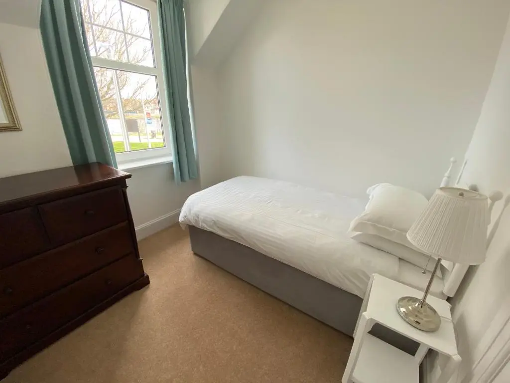 a bedroom with a bed with a lamp and a window at Stanford House in Inverness